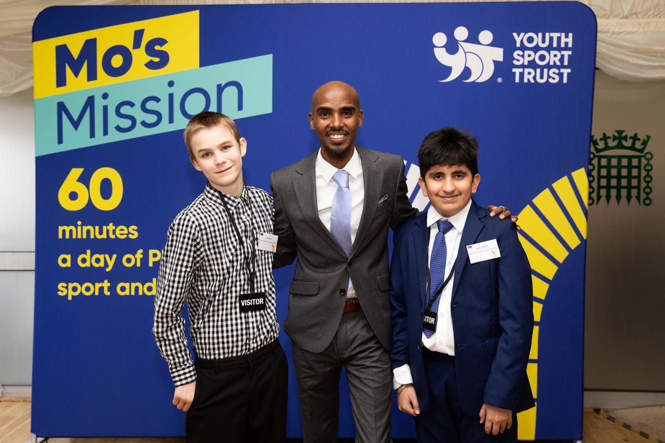 Mo Farah and students in front of Mo's Mission banner at launch of our manifesto in Parliament