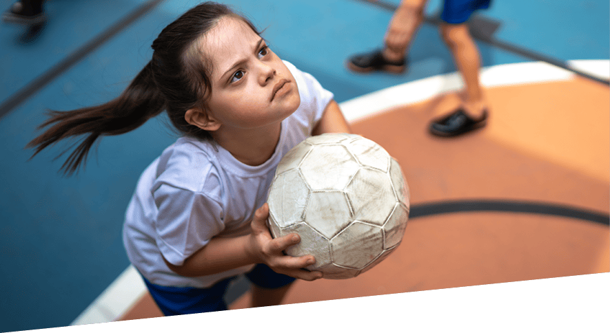 Young girl focused on target with football in hands ready to throw