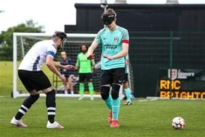 Image of two young people playing football, whilst wearing blindfolds.
